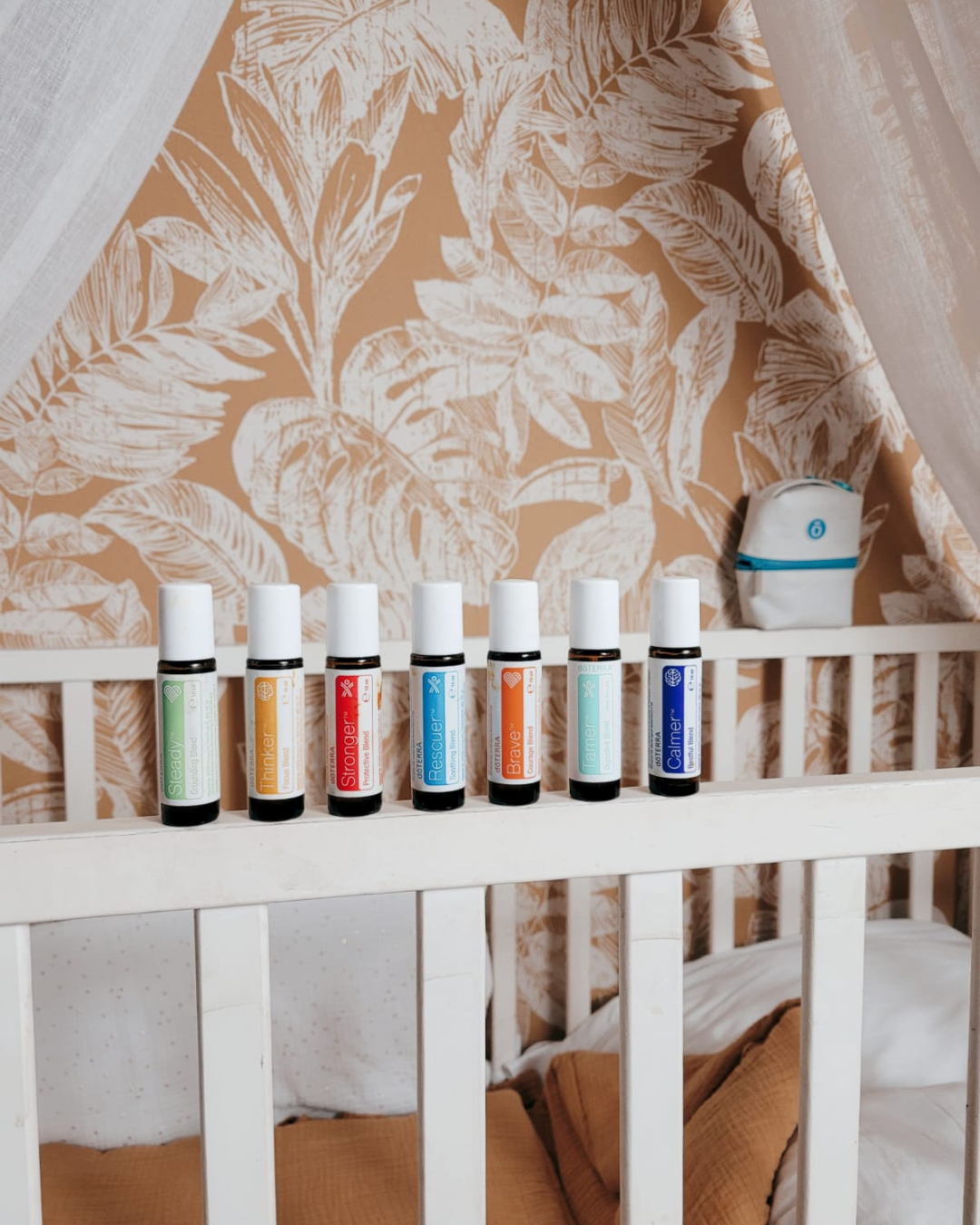 Les 7 roll-on du Kit enfant alignés sur le rebord d’un lit d’enfant