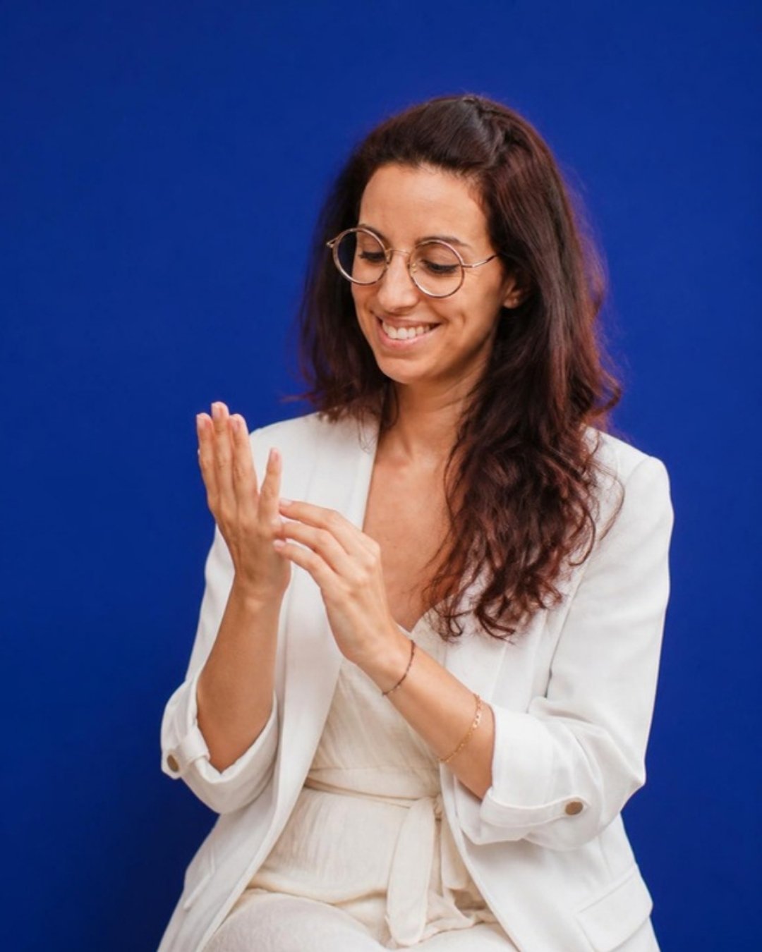 Marion en blazer blanc sur fond bleu